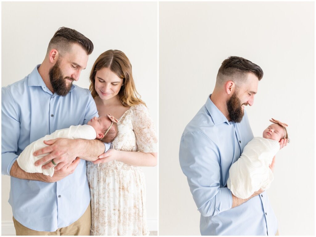 Mom and Dad holding newborn baby girl swaddled 