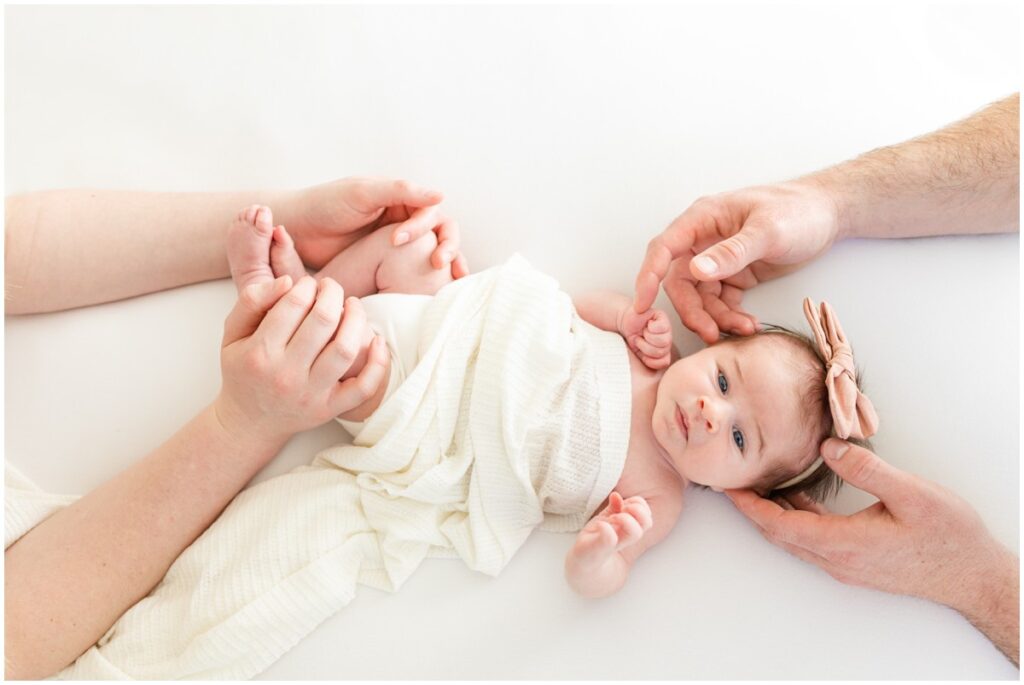 Newborn Baby girl with mom and dad's hands