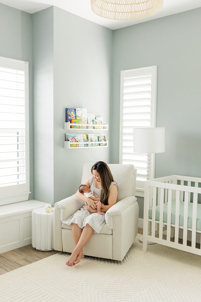 mom in nursery holding baby with OKC in-home newborn photographer