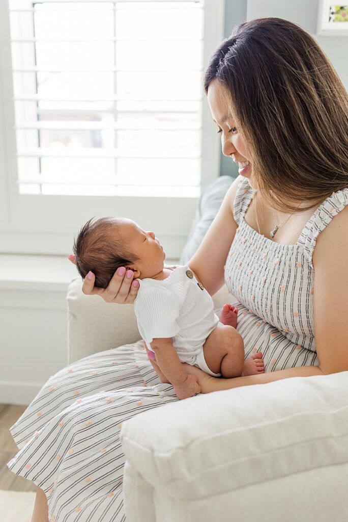 Mother holding newborn baby at session with OKC in-home newborn photographer