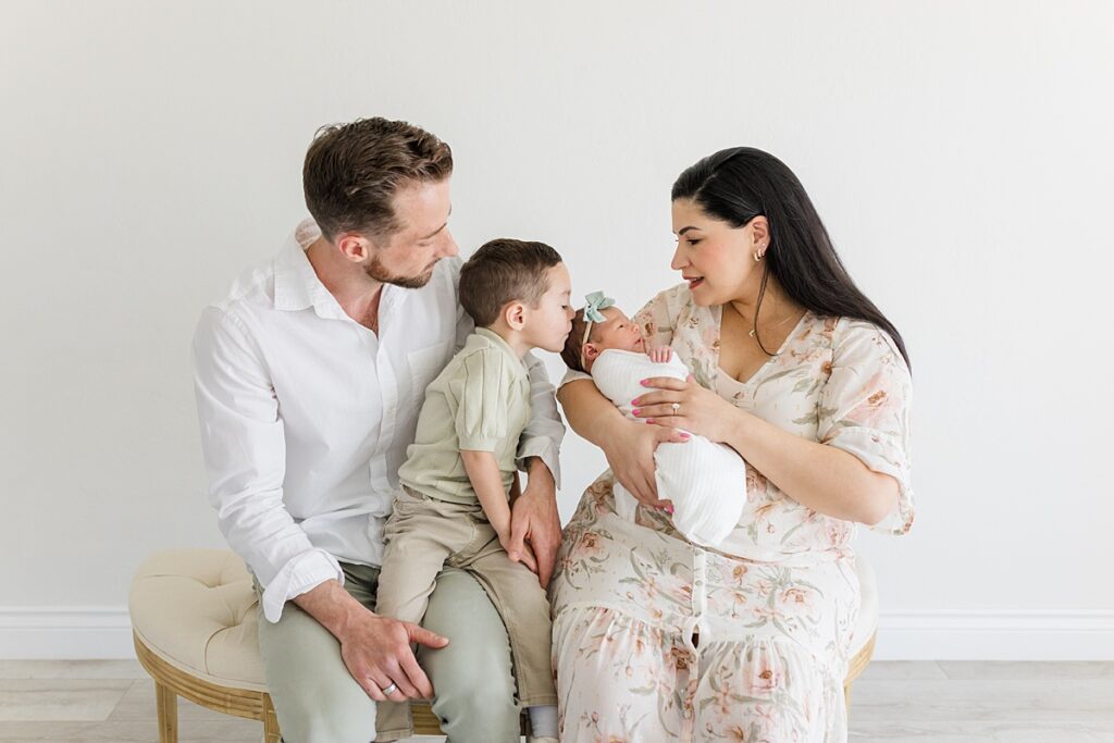 Family with swaddled newborn in okc newborn photographer studio